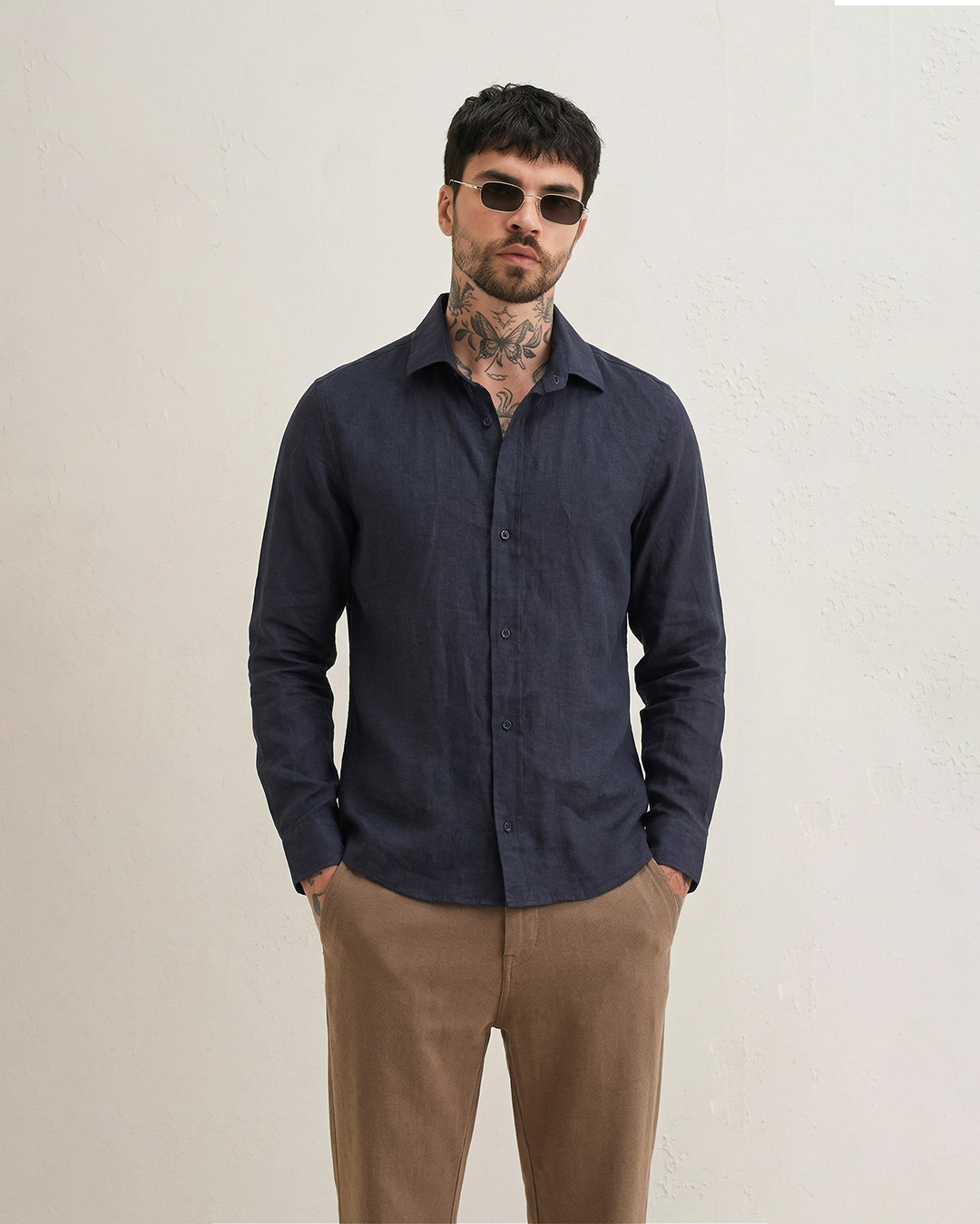 Full outfit look with AERAA navy linen shirt and beige trousers