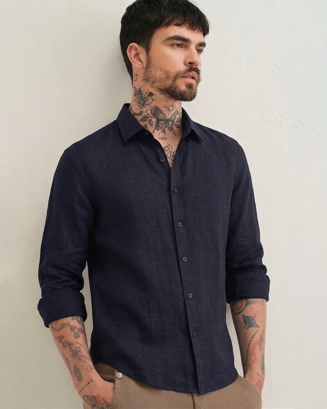 Side profile of model wearing AERAA navy linen shirt